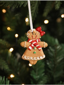 Detailed view of gingerbread girl resin pendant with red bow hanging on Christmas tree