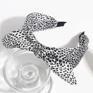 Detail of fashion headband with black and white leopard print and top knot bow design