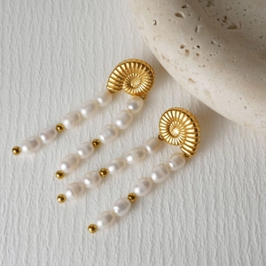 Detail of seashell earrings with gold metal top and double rows of white pearls