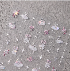Close-up of ballet-themed nail stickers featuring pink swans, roses, and glitter details