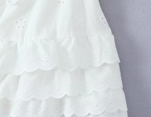 Détail du tissu en coton blanc Broderie Anglaise avec des volants étagés