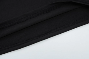 Detailed macro shot of fine double stitching and black knitted fabric texture on the garment
