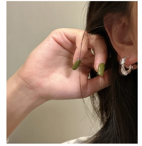 Close-up of S925 sterling silver knotted rope earrings worn on ear with minimalist style