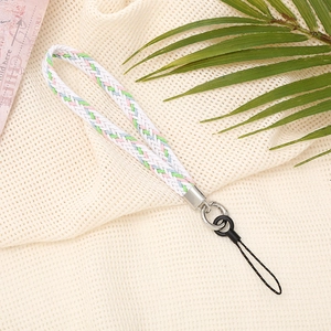 Detail of woven wrist strap in white, pink and blue with silver metal buckle on beige fabric