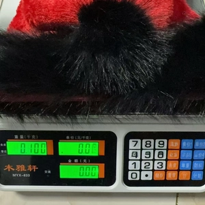 Detailed weight measurement showing the 100g red and black plush Christmas hat on a scale