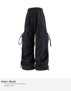Dettaglio dei pantaloni cargo neri con vita elastica a coulisse e nastri decorativi