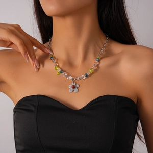 Détail du collier de perles en verre bohème avec pendentif fleur en métal sur le cou