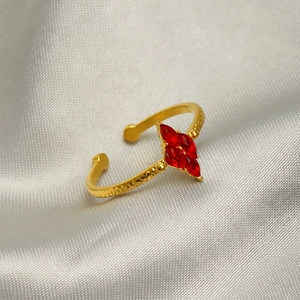 Detailed macro view of gold-plated ring featuring red marquise-cut zircon stones