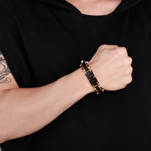 Détail d'un bracelet bicolore noir et or en acier inoxydable pour homme avec fermoir pliant