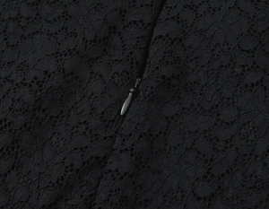 Close-up of black lace fabric detail and invisible zipper on short dress