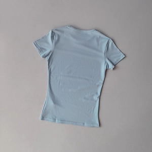 Flach liegendes hellblaues Slim-Fit Yoga-T-Shirt auf grauem Hintergrund