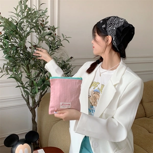 Handheld view of pink and green cotton makeup pouch with a stylish zipper detail