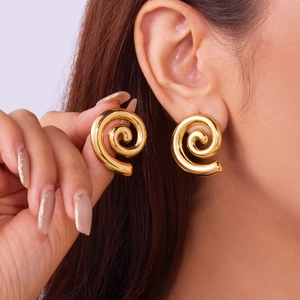 Golden spiral conch earrings in titanium steel with textured beach style on ear model