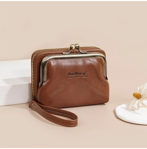 Detail of brown leather coin purse with bronze clasp, zipper pocket and wrist strap