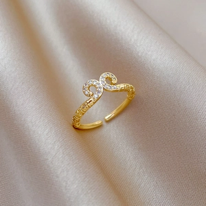 Macro detail of gold adjustable ring featuring cloud patterns and sparkling white zircons