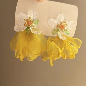 Macro view of 3D yellow chiffon petal earrings with resin flower and green leaf details