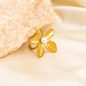 Gold flower open ring with pearl center on pink stone and beige silk background