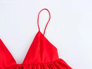 Détail du décolleté en V et du tissu en satin lisse sur ce débardeur caraco rouge élégant