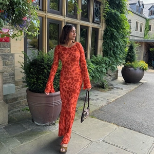 Elegant orange floral maxi dress with flared sleeves shown in a scenic outdoor setting