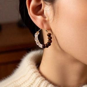 Detail shot of vintage hoop earrings with zircons and tiger eye stones on model