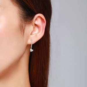 Elegant s925 silver heart drop earrings with shimmering crystals worn by a model