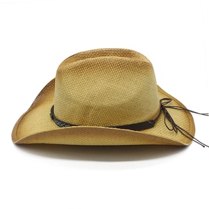 Detail of hand-woven straw cowboy hat featuring brown leather band and rustic textures