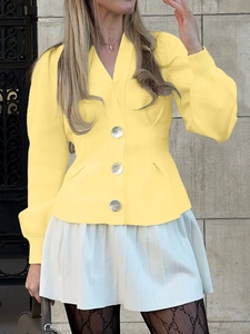 Detail of yellow V-neck knit cardigan featuring button closure and elegant puff sleeves