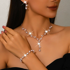 Elegant rose gold jewelry set with white pearls and crystals on female model