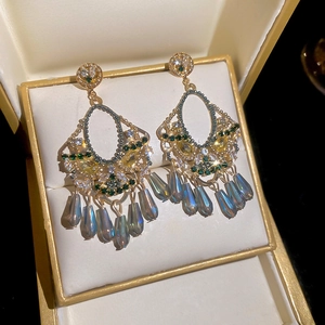 Detail of luxury crystal tassel earrings with colorful rhinestones on a velvet tray
