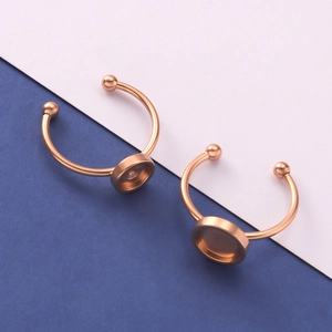 Detail of two rose gold stainless steel DIY ring bases with round tray settings