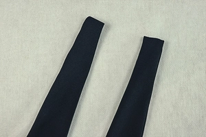 Detail of navy blue ruched dress shoulder straps showing high-quality stitching texture