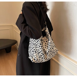 Detail of a large leopard print canvas tote bag shown on model with natural drape