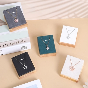 Elegant wooden necklace display stands with assorted pendant jewelry on a beige background