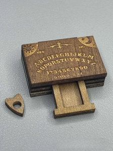 Detail of miniature wooden Ouija board box with laser engraved sun and moon patterns