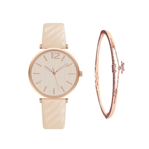 Detail of rose gold quartz watch with leaf pattern dial and star charm bracelet