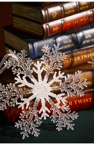 Macro shot of large transparent snowflake ornament with glittering texture and ribbon