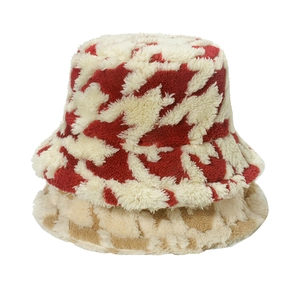Close-up of thick houndstooth plush bucket hats in red and beige for winter warmth