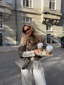 Dettaglio di una giacca alla moda sciancrata con borsa in pelle in un look street style