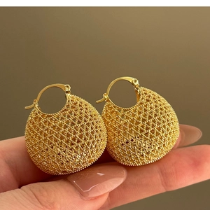 Retro gold woven hollow ball earrings with intricate mesh texture and hoop closure