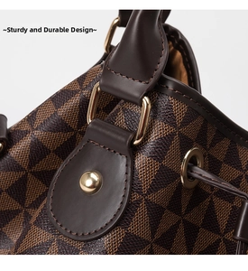 Macro shot of gold D-ring hardware and reinforced stitching on a brown bucket bag