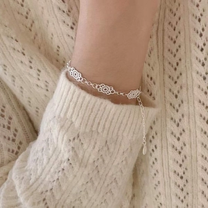 Elegant S925 sterling silver lace flower bracelet worn over a cozy cream knit sweater