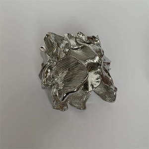 Macro detail of the silver metal petal texture on this wide floral cuff bracelet