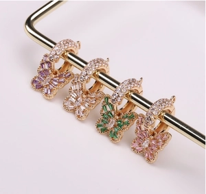 Macro shot of colorful hollow butterfly pendants with inlaid zircons in gold plating