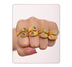Detail of gold snake-textured ring with heart-shaped colorful cubic zirconia inlay