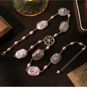 Macro detail of Baroque pink pearl long necklace with golden chain and round accents