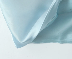Detail of light blue satin fabric showing smooth texture and high-quality stitching