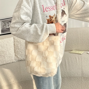 Detail view of large cream checkerboard faux fur tote bag with wide plush shoulder strap