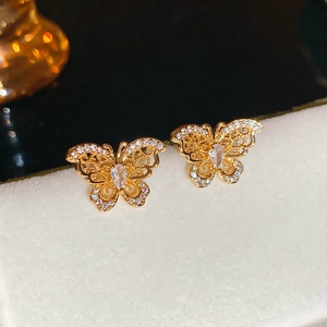 Detailed close-up of gold butterfly stud earrings with sparkling cubic zirconia stones
