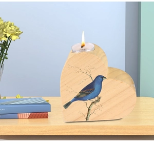 Detail of heart-shaped pine wood candle holder with blue bird illustration and tea light