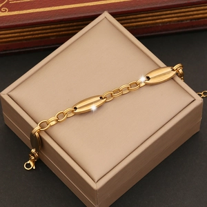 Close-up of gold pig nose chain bracelet on a beige jewelry box with luxury finish